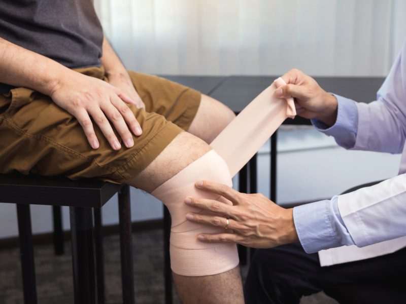 Asian physiotherapists are examining the results of knee surgery.